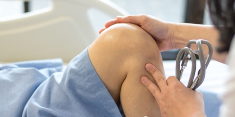 Doctor check up or exam patient knee bone and joint for patellofemoral infection and osteochondritis