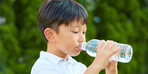 A kid drinking bottled water