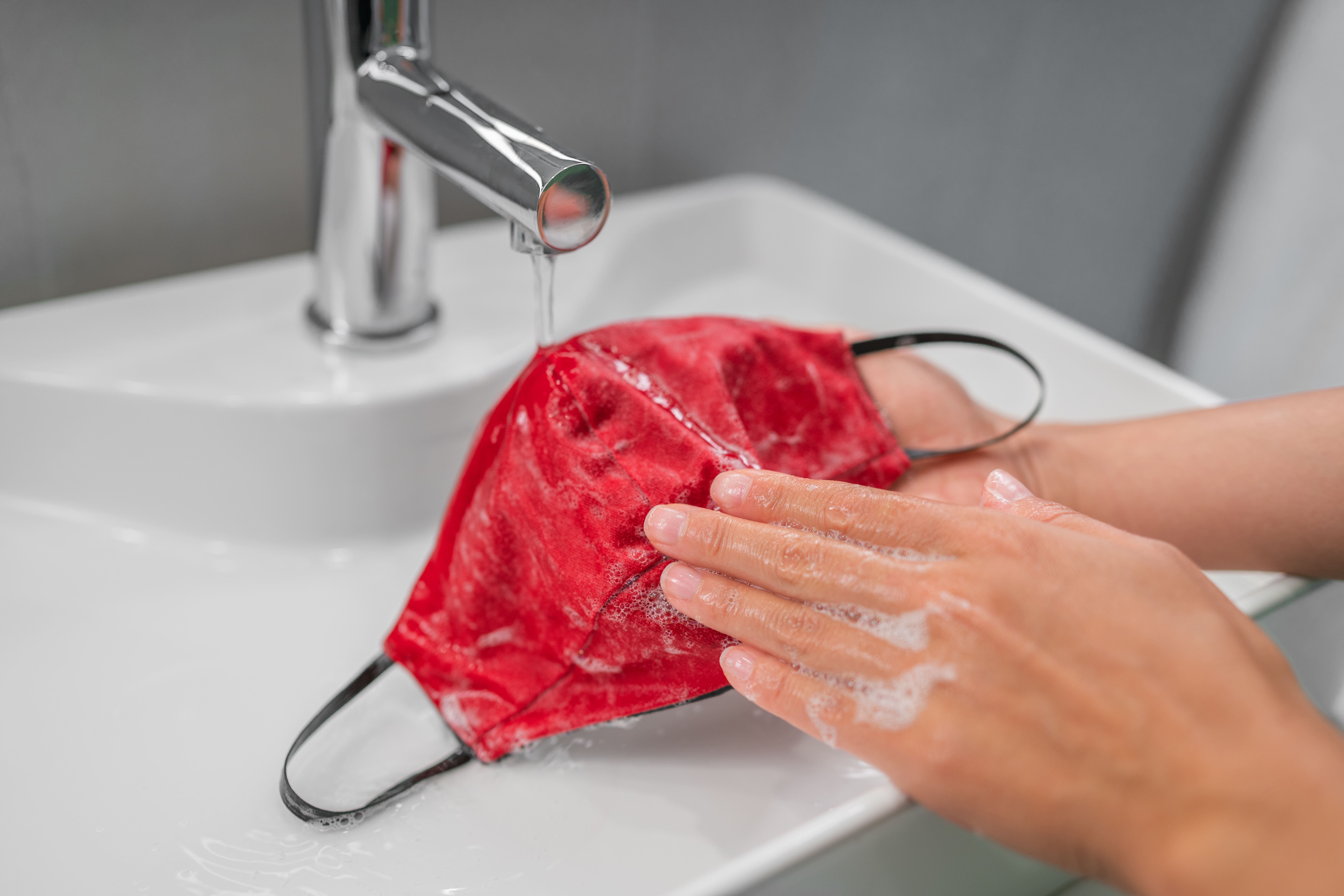 person washing a face mask