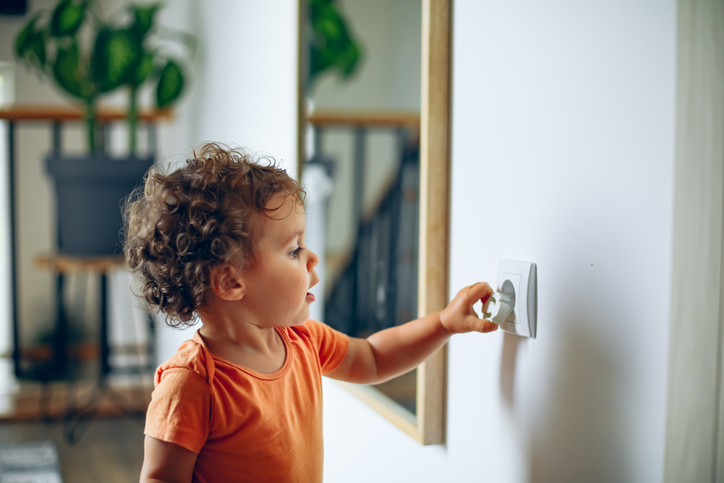 Toddler playing with plug socket