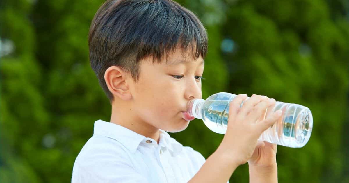 A kid drinking bottled water